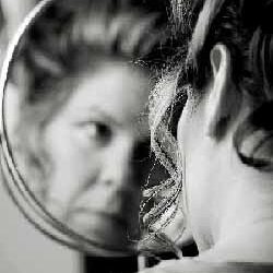 Analyze the use of metaphor in Sylvia Plath's Mirror